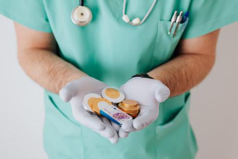 pièces et billets dans les mains d'un soignant