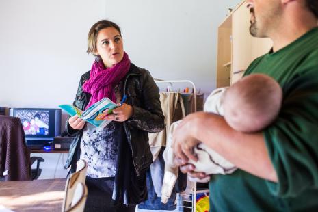 Infirmière puéricultrice du service de PMI en visite postnatale au domicile d'un nouveau-né. 