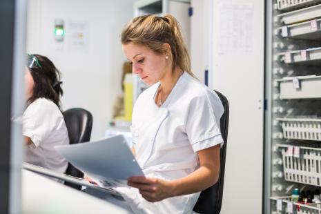 Infirmière en poste en train de consulter un document