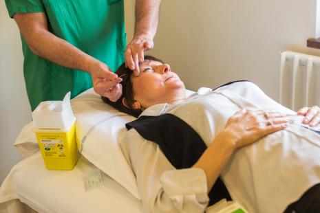 Patiente atteinte d'un cancer, traitée par chimiothérapie, pendant une séance d'acupuncture à l'hôpital.