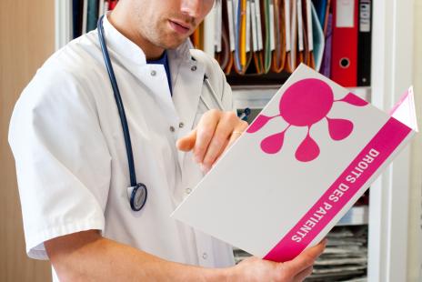 Médecin consultant une brochure d'information sur les droits des patients.