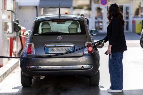 Femme faisant le plein d'essence à une station.