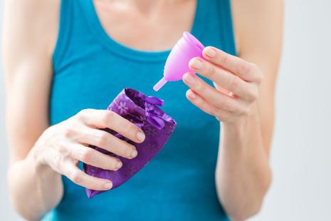 Femme tenant une coupe menstruelle