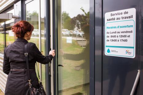 Femme franchissant la porte d'un service de santé au travail