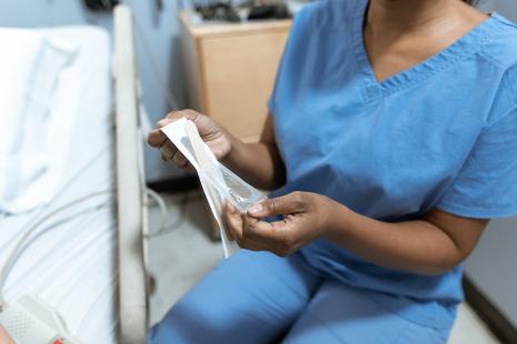 Infirmière hospitalière s'apprêtant à poser un pansement