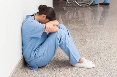 Infirmière triste assis dans un couloir