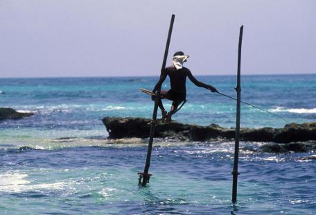 Sur la côte sud, pêcheur à échasses
