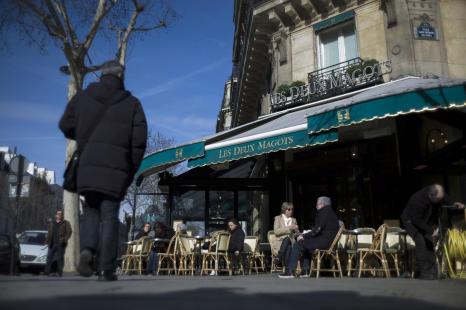 People have a drink at the terrace of 'Les Deux Magots' cafe in the Saint-Germain-des-Pres area,...