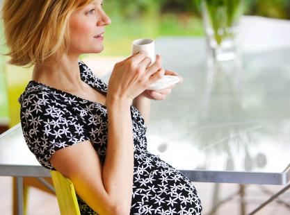 Femme enceinte buvant du café.
