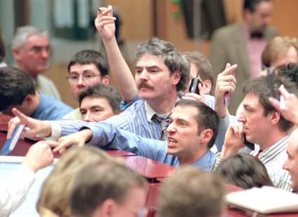 Traders signal at the Frankfurt stock exchange 20 March, where the DAX index broke up through the...